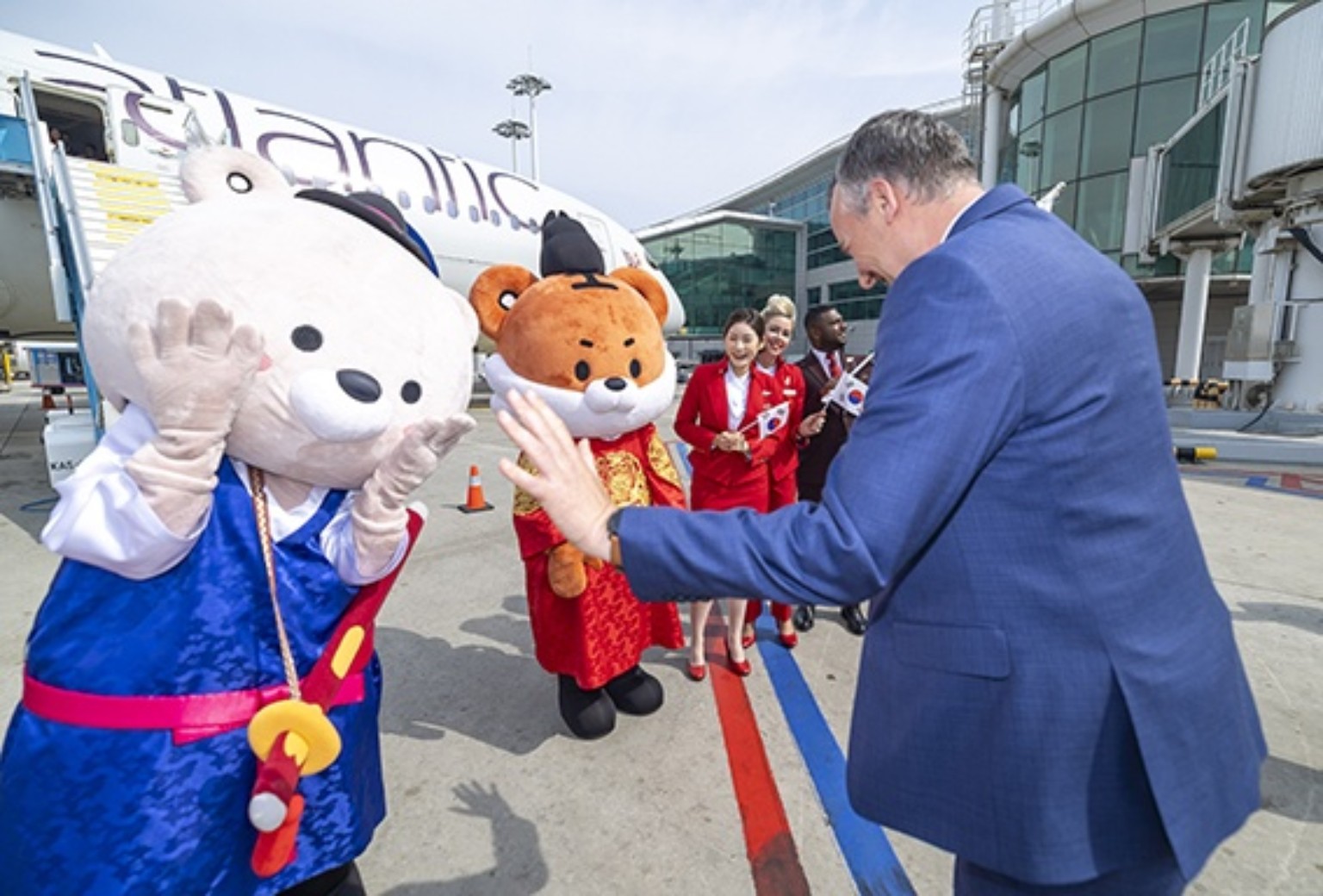 버진애틀랜틱 관계자가 인천국제공항 계류장에서 한국관광공사 마스코트와 인사를 나누고 있다