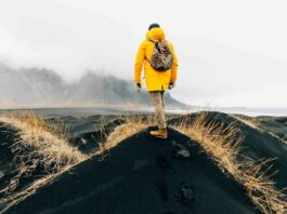 한국 여행객, 이제 ‘날씨’ 보고 떠난다 악천후가 드리운 해안 풍경 앞에 서 있는 여행자의 뒷모습