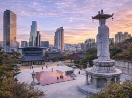 Bongeunsa Temple courtyard and standing Buddha statue with the Gangnam skyline at sunset in Seoul