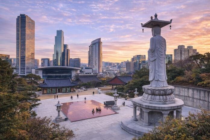 ChatGPT Image 2026년 4월 16일 오후 02_43_58 Bongeunsa Temple courtyard and standing Buddha statue with the Gangnam skyline at sunset in Seoul