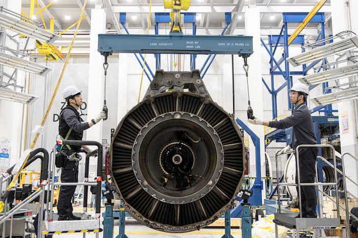 Engineers inspecting a large aircraft engine at Korean Air maintenance facility