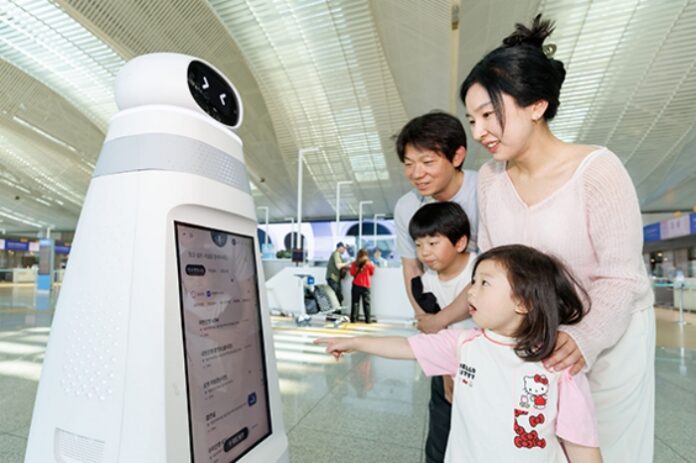 incheon-airport-ai-robot-passenger-service 인천공항에서 가족 여행객이 안내 순찰 로봇을 이용해 공항 정보를 확인하는 모습