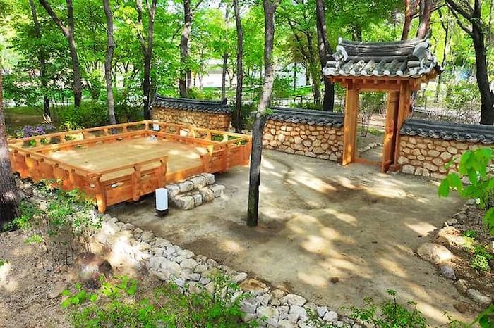 K-헤리티지정원의 오솔길과 협문, 전통 담장이 이어지는 장면