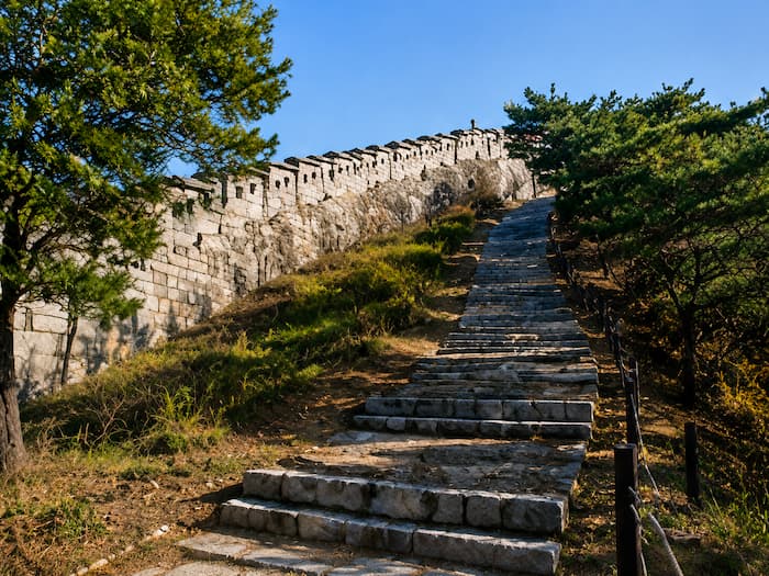 Stone steps climb beside the Seoul City Wall on the Bugaksan section