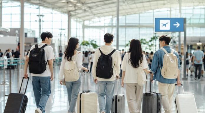 짧은 해외여행을 떠나기 위해 공항 출국장으로 향하는 젊은 한국인 여행자들