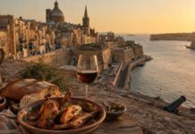 A Maltese table with rabbit stew, bread, olives, and wine overlooking Grand Harbour in Valletta