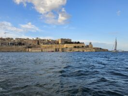 Malta seaward fortifications and sailing boat in Grand Harbour