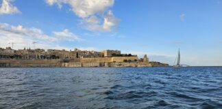 Malta seaward fortifications and sailing boat in Grand Harbour