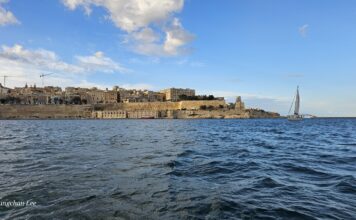 Malta seaward fortifications and sailing boat in Grand Harbour
