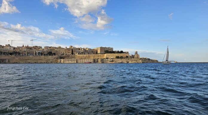 Malta seaward fortifications and sailing boat in Grand Harbour