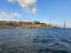 Malta seaward fortifications and sailing boat in Grand Harbour