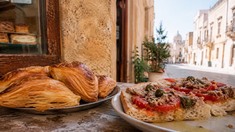 Maltese pastizzi and ftira served on a street-side table