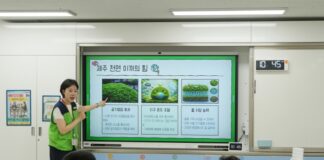 서울서진학교 복도에 마련된 제주 숲 사진 전시를 학생들이 관람하는 모습