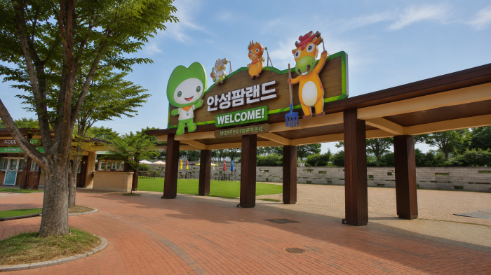 나무 그늘과 풍차가 보이는 안성팜랜드 입구 광장