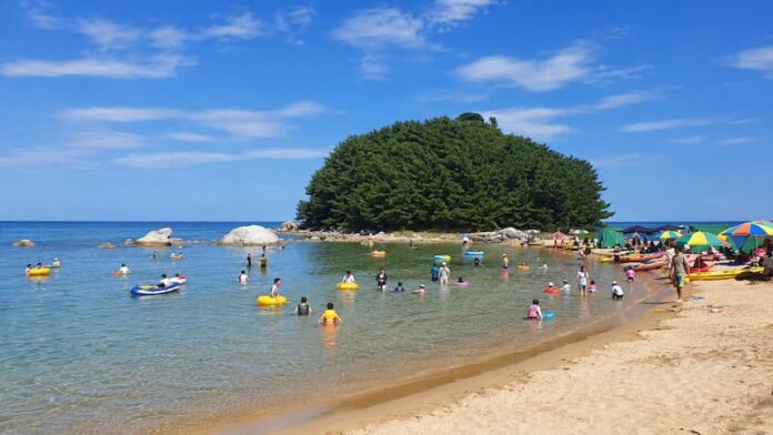 goseong-machajin-beach-musongdae-family-waterplay 무송대와 얕은 바다에서 가족들이 물놀이하는 고성 마차진해수욕장