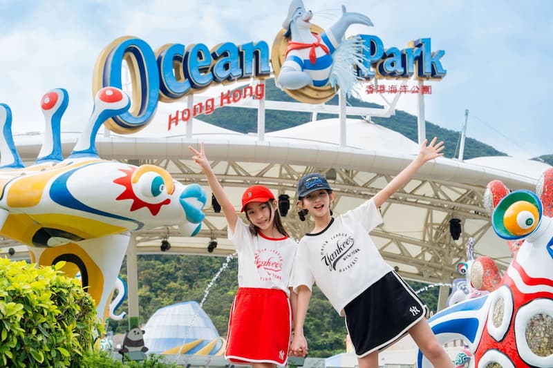 홍콩 오션파크 입구에서 손을 들고 기념사진을 찍는 어린이 두 명