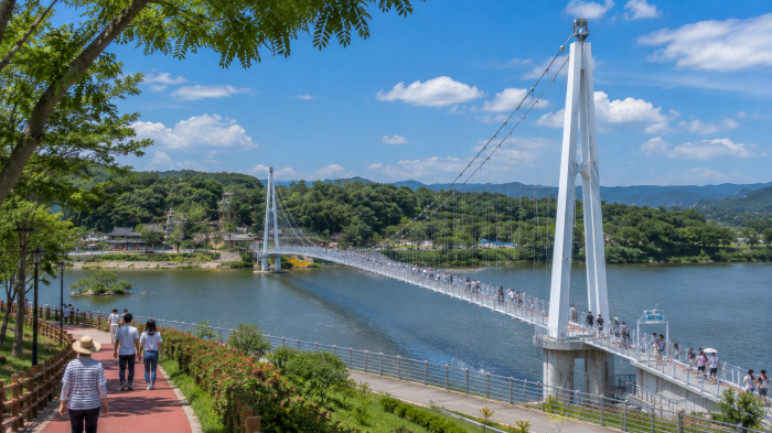 여주 남한강 출렁다리를 걷는 여행객과 수변 산책로