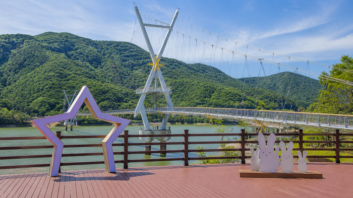 별 모양 포토존과 출렁다리가 함께 보이는 수변 전망대