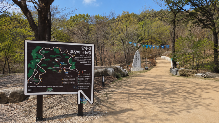 인천 도심을 배경으로 세워진 만수산 무장애나눔길 안내 표지