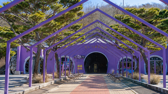 보라색 구조물과 동굴 입구가 이어지는 울산 자수정동굴나라