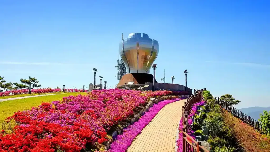 꽃밭 너머로 보이는 광양 구봉산 디지털 메탈아트 봉수대